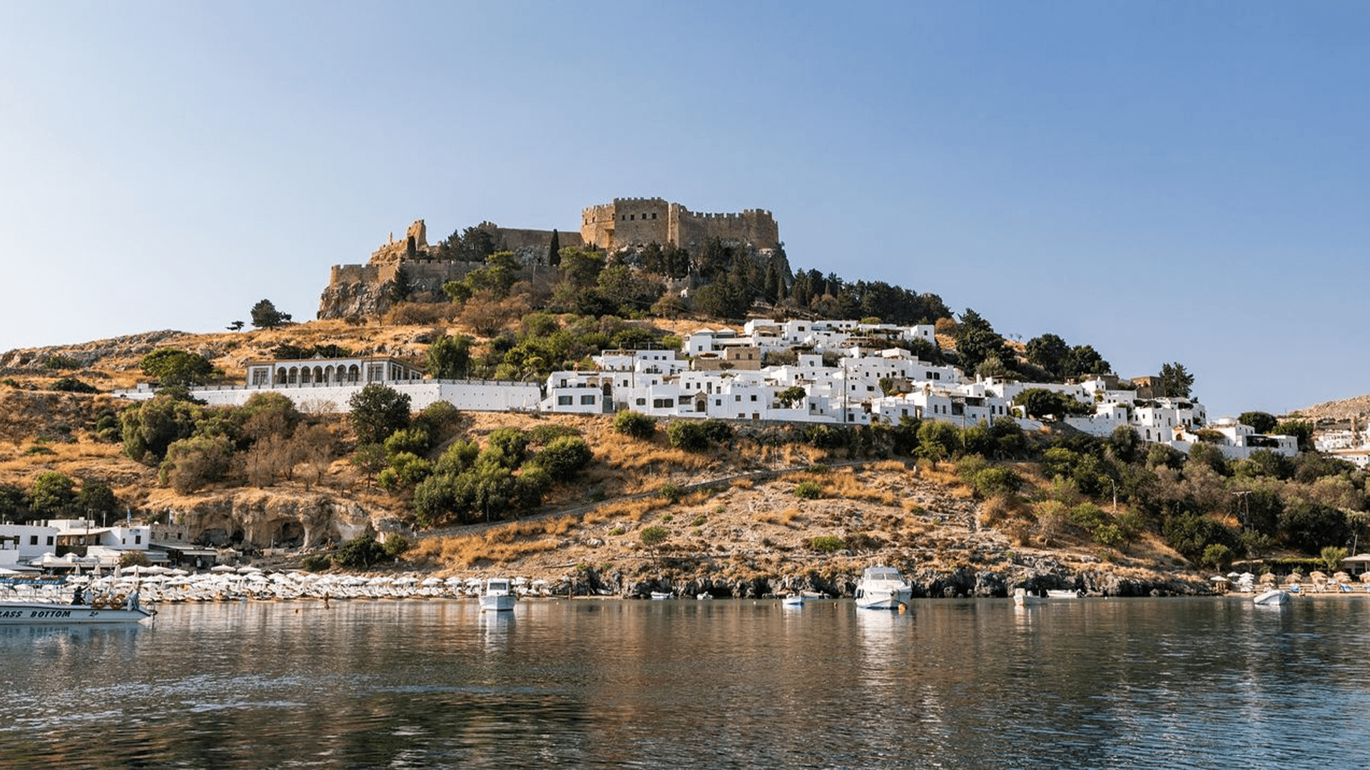 View of Rhodes, Greece, from the water, with the island’s coastline and historic town rising above the Aegean Sea.